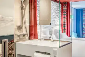 Een kamer met een tweepersoonsbed en een wastafel.