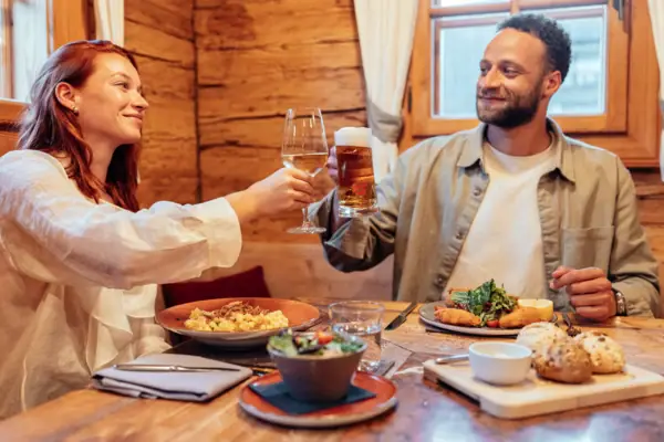 Stroblhaus Een man en een vrouw houden wijnglazen vast.