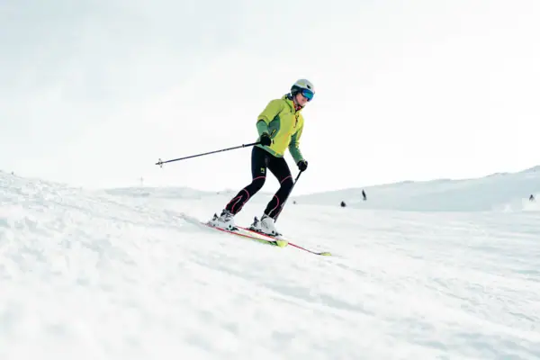 Skiën Iemand skiet een besneeuwde helling af.
