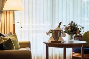 Senior Suite Een tafel met een emmer champagne en bloemen erop.