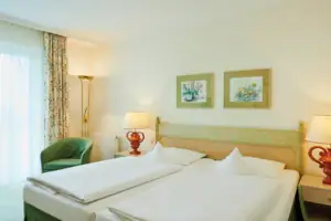 Tweepersoonskamer met uitzicht op het meer Een kamer met twee bedden en een lamp.