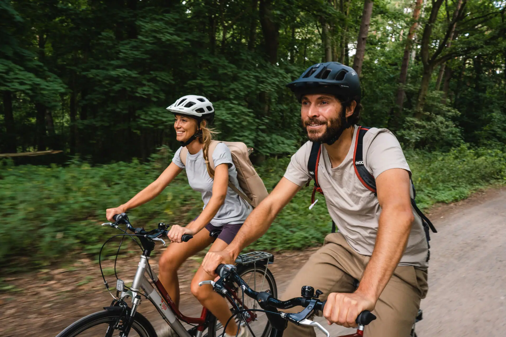 Een man en een vrouw fietsen in het bos.