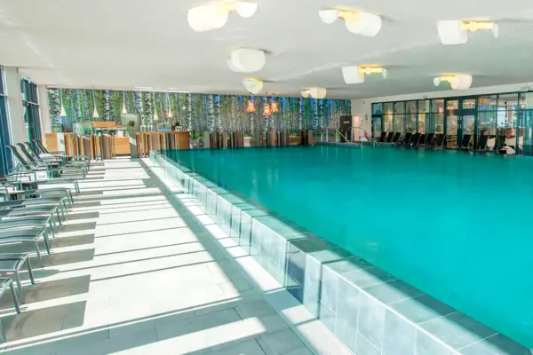 Ein großer Innenpool mit einer Poolbar im Hintergrund.