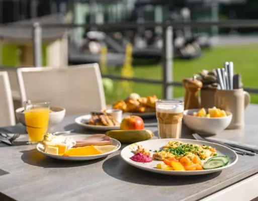Ontbijt Een tafel met borden vol eten en drinken.