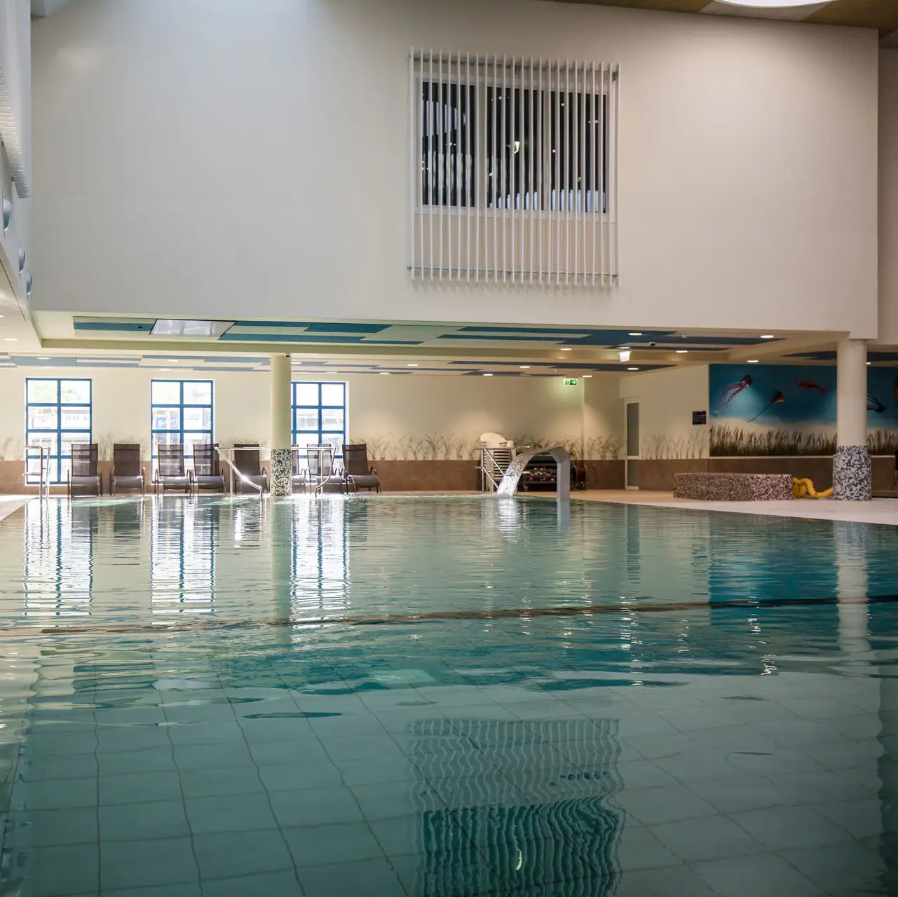 Groot binnenzwembad met helder water.