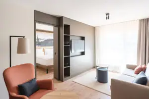 Junior Suite Uitzicht op de Bergen Een kamer met een televisie en een bank.