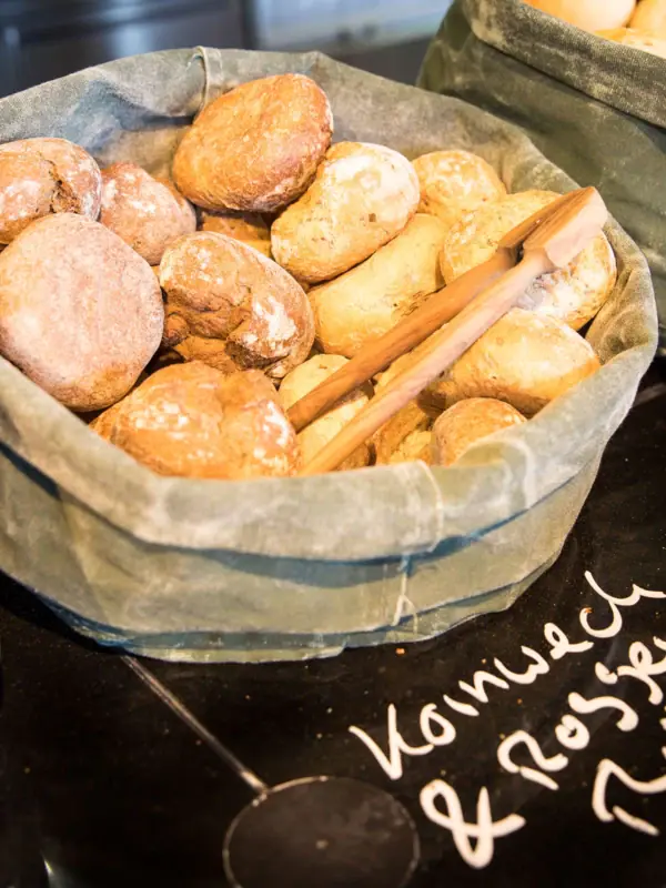 Ontbijt bij JEDERMANNS Een stapel broodjes in manden.