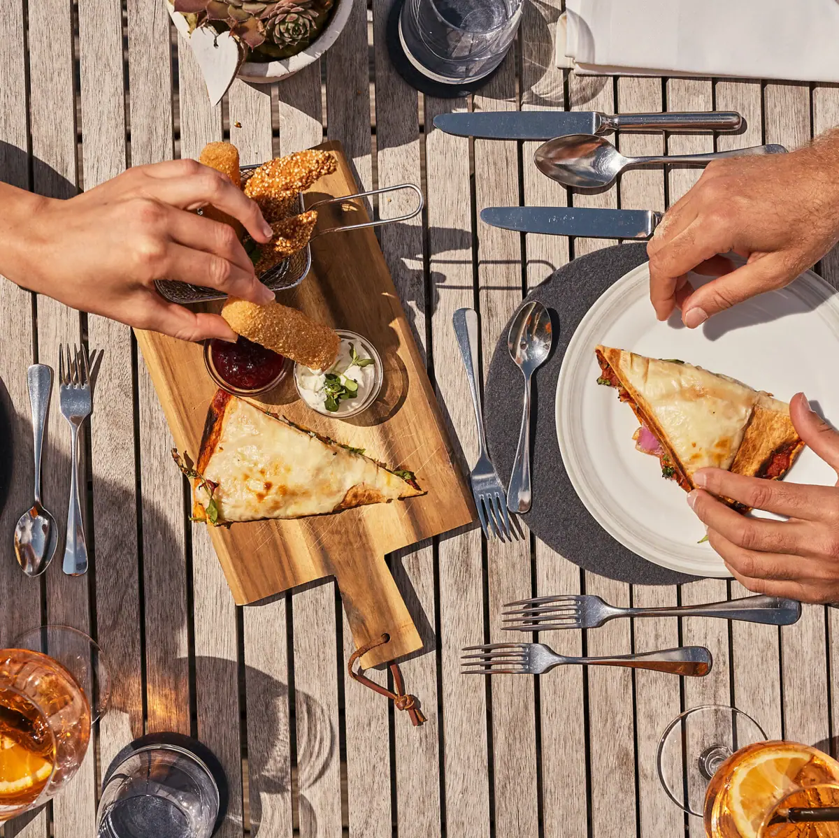 Er zit iemand aan een tafel fastfood te eten.
