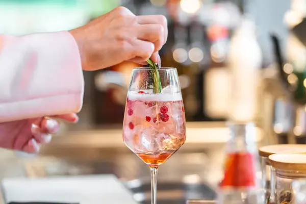 Iemand legt een vel papier op een drankje in een glas.