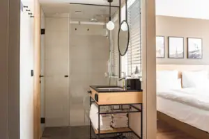 Familiekamer Een badkamer met een glazen deur in de douche.