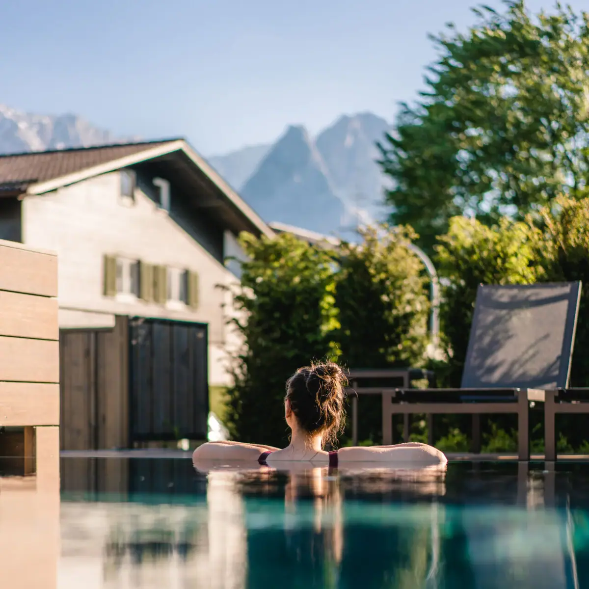 Buitenzwembad Een vrouw zwemt in een buitenzwembad.