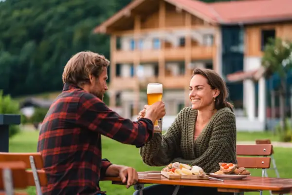 Ein Mann und eine Frau sitzen an einem Tisch mit Essen und Getränken.