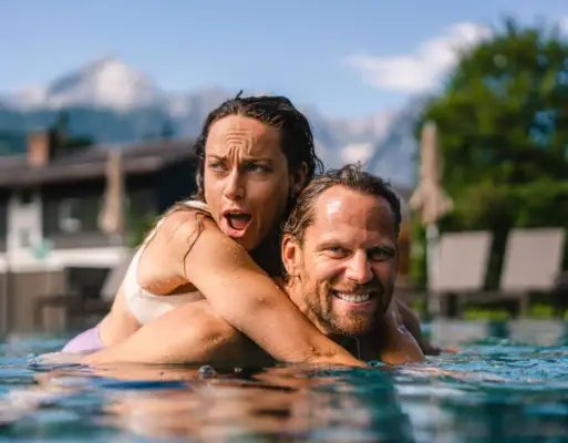 Paar in het zwembad Een man en een vrouw in het zwembad, lachend.