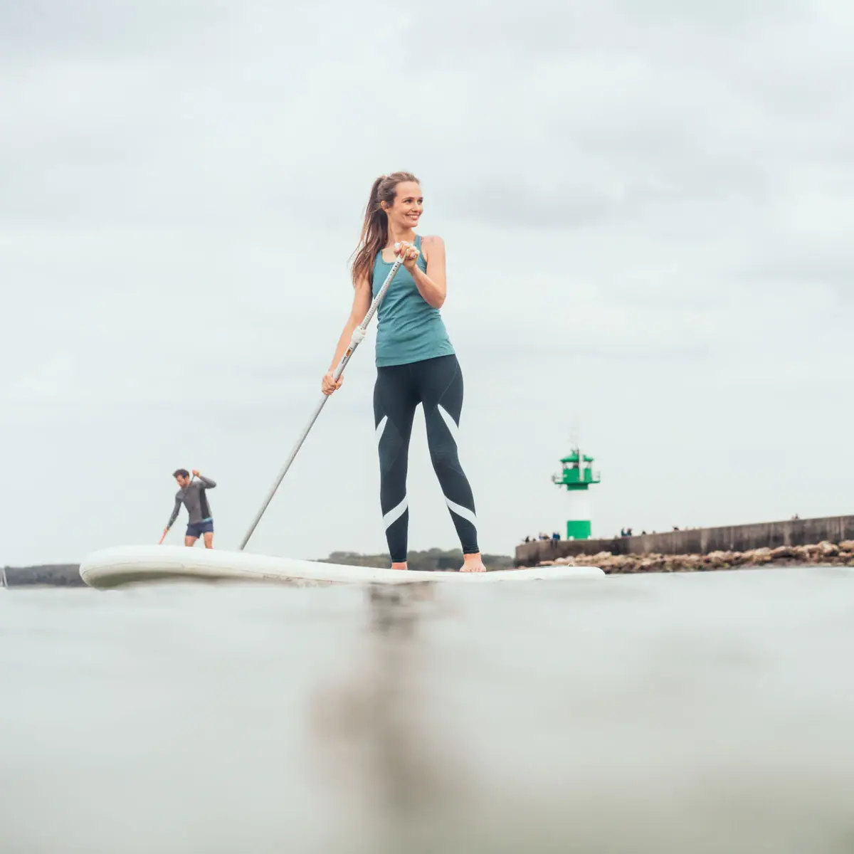 SUP op de Oostzee Een vrouw en een man op een surfplank op het water.