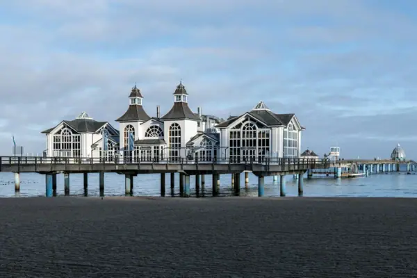 Een gebouw op een steiger aan het water onder een bewolkte hemel.