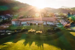 Ein großes Gebäude mit einem großen Rasen und einem Parkplatz.