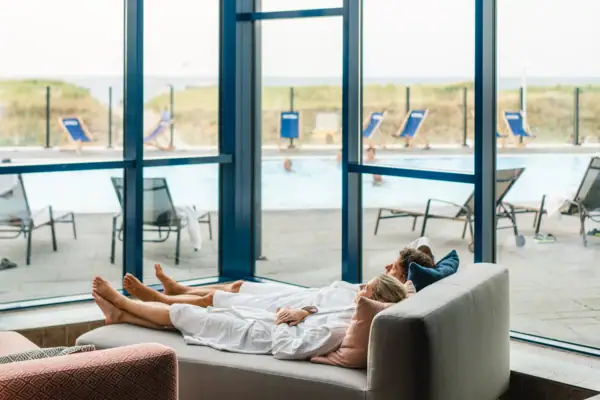 Ontspanningsruimte bij de aja Warnemünde Een koppel ligt op een sofa.