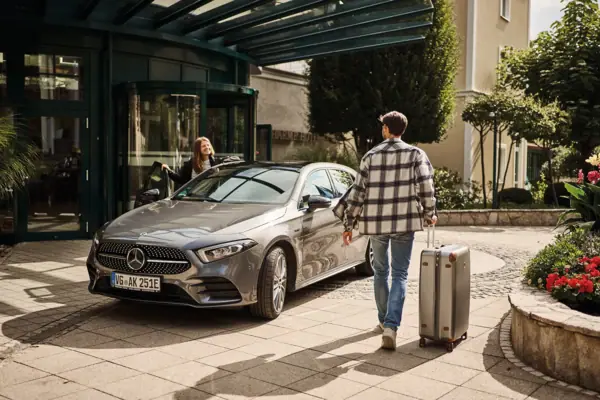 Parkeren Een man en een vrouw met bagage voor een auto.