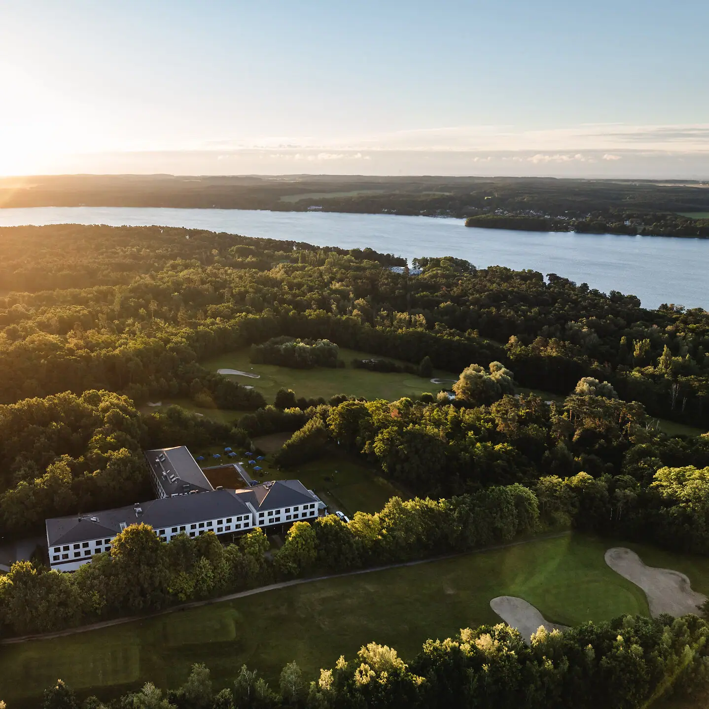 Een groot wateroppervlak met een gebouw en bomen.