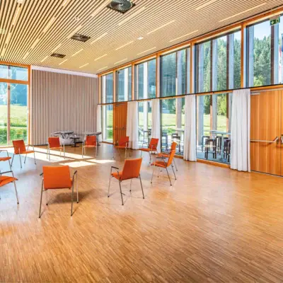 Een kamer met stoelen en tafels.