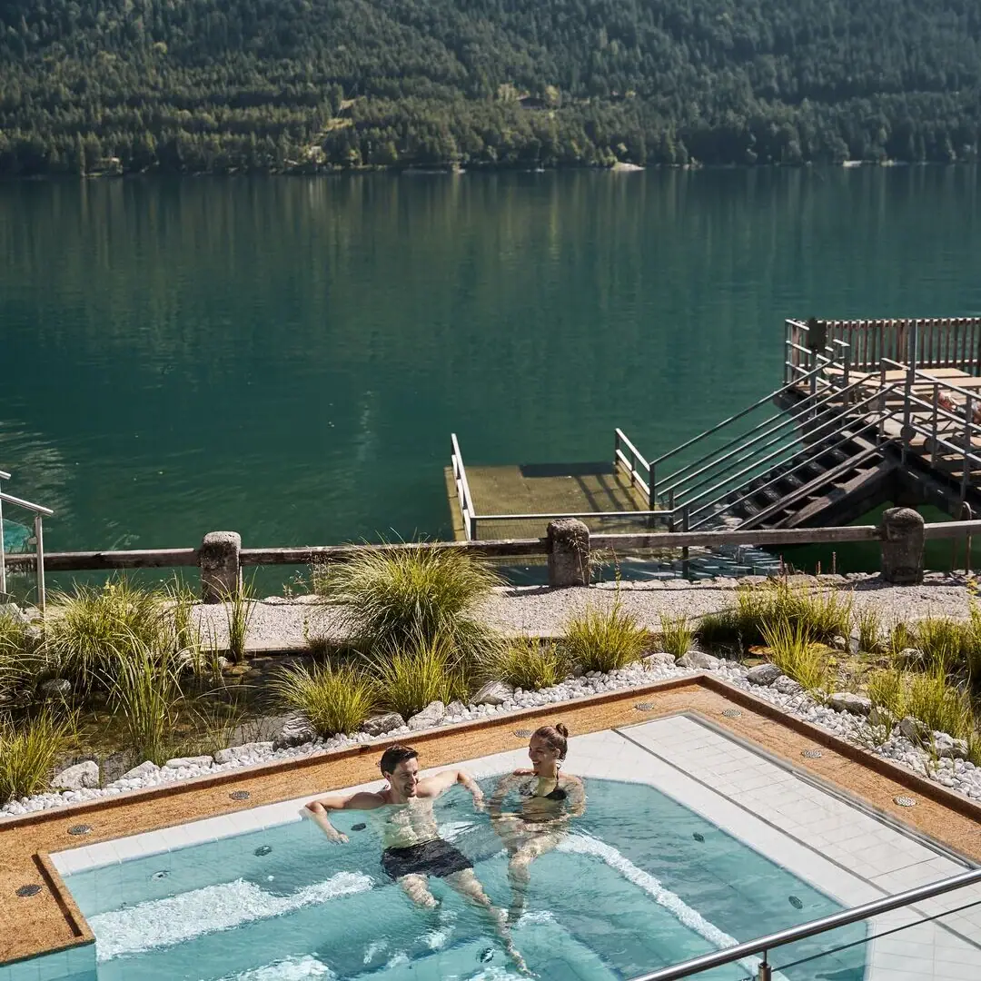 Whirlpool Mensen in een zwembad met een waterlichaam en bergen op de achtergrond