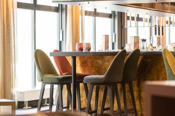 Een ruimte met een bar en stoelen.