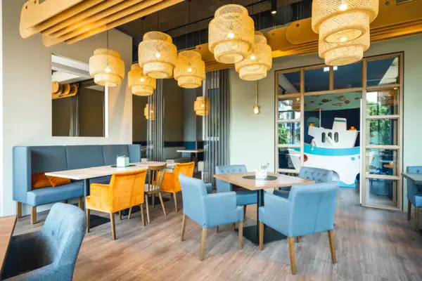 Restaurant en bar bij aja Warnemünde Een kamer met een tafel en stoelen op de achtergrond is de speelkamer.
