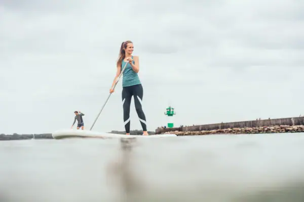 SUP op de Oostzee Een vrouw en een man op een surfplank.