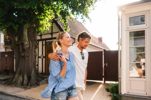 Een man en een vrouw lopen over een stoep.