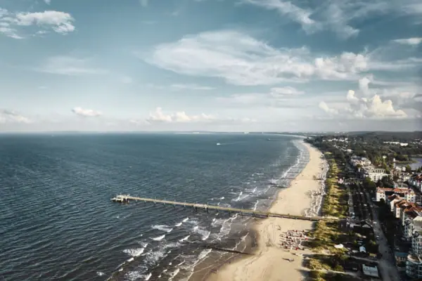 Lange pier op het strand met uitzicht op de zee en de lucht.