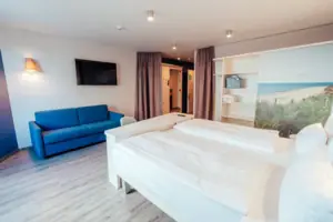 Een kamer met twee bedden en een blauwe bank.