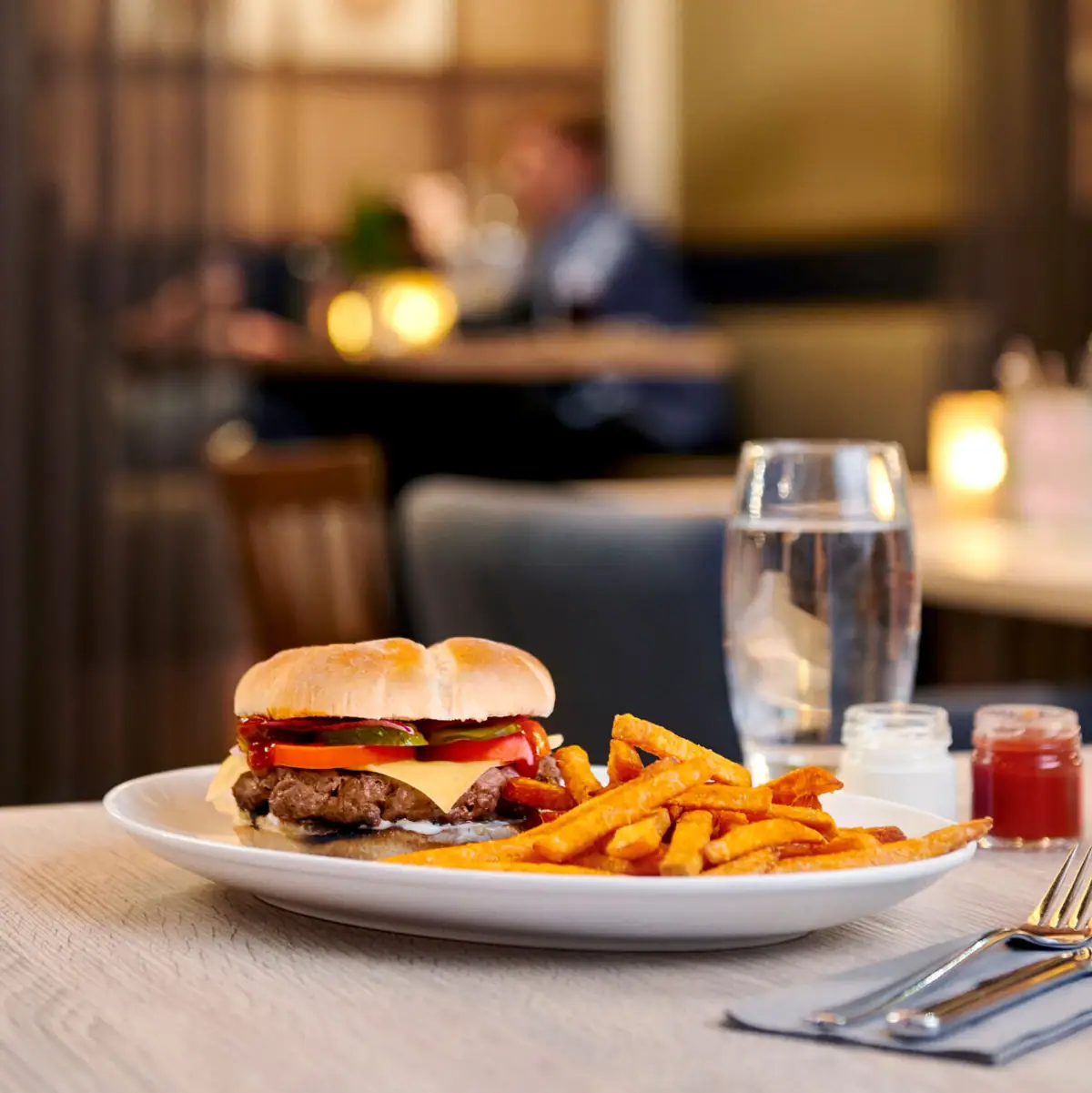 Een bord hamburgers en friet op tafel.