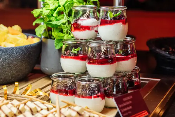 Oudejaarsbuffet bij aja Bad Saarow Een selectie desserts in glazen op een tafel.