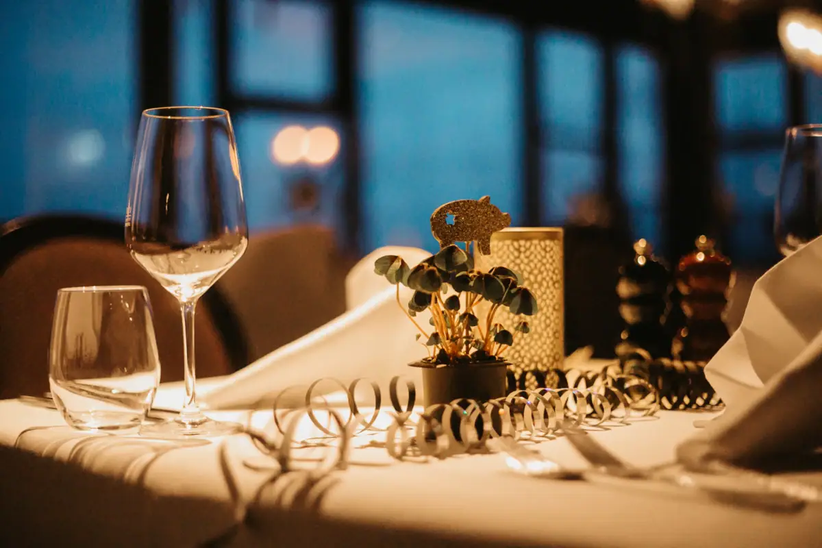 Een tafel met een wijnglas en een plant erop.