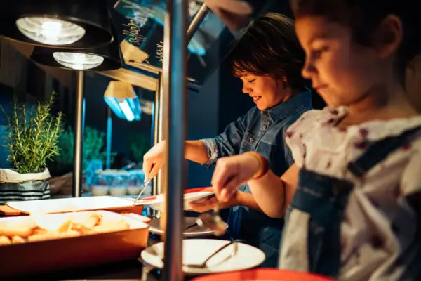 Kindergroep aan het buffet met verschillende gerechten.