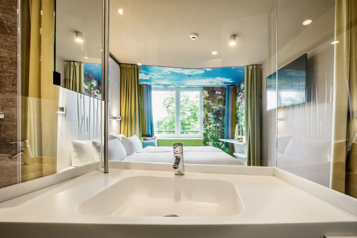 Kamers in het aja Bad Saarow Een wastafel in een kamer met muur en kraan.