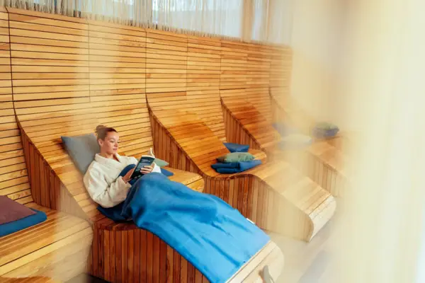 Ontspanningsruimte Er zit een vrouw op een houten stoel.