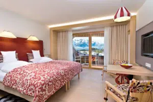 Een kamer met een bed, een tafel en stoelen.