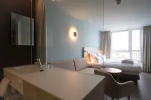 Tweepersoonskamer Een kamer met een bed en een bank.
