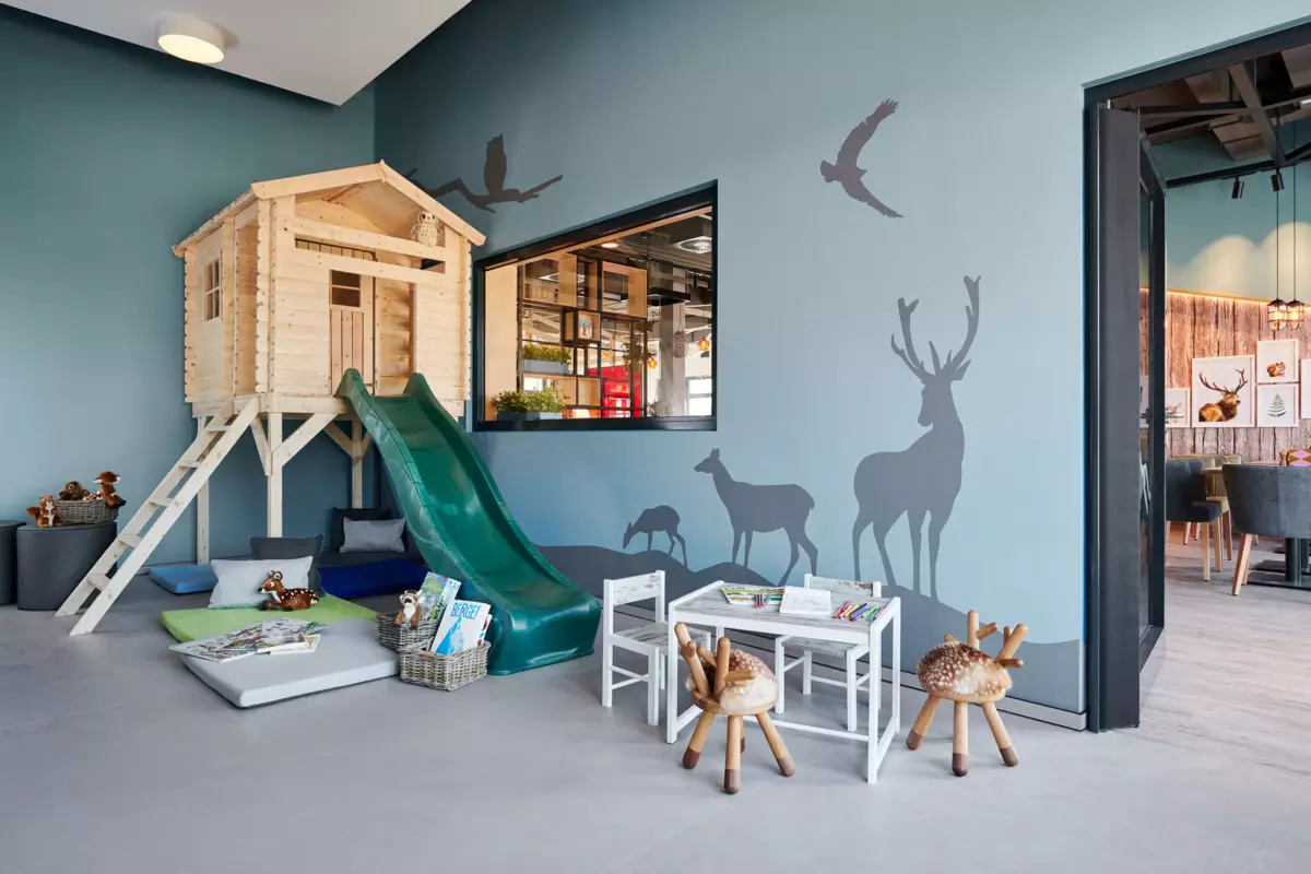 Een kamer met een glijbaan en een muurschildering.