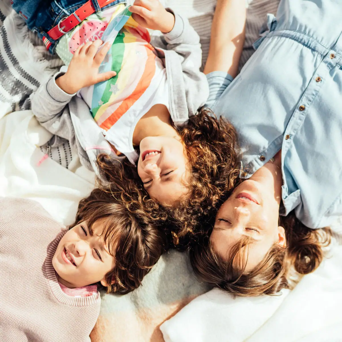 Familie op het strand Een groep mensen ligt op een deken.