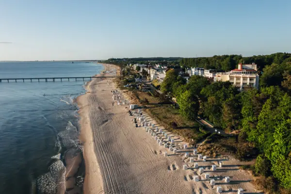 Strand met gebouwen en bomen op de voorgrond.
