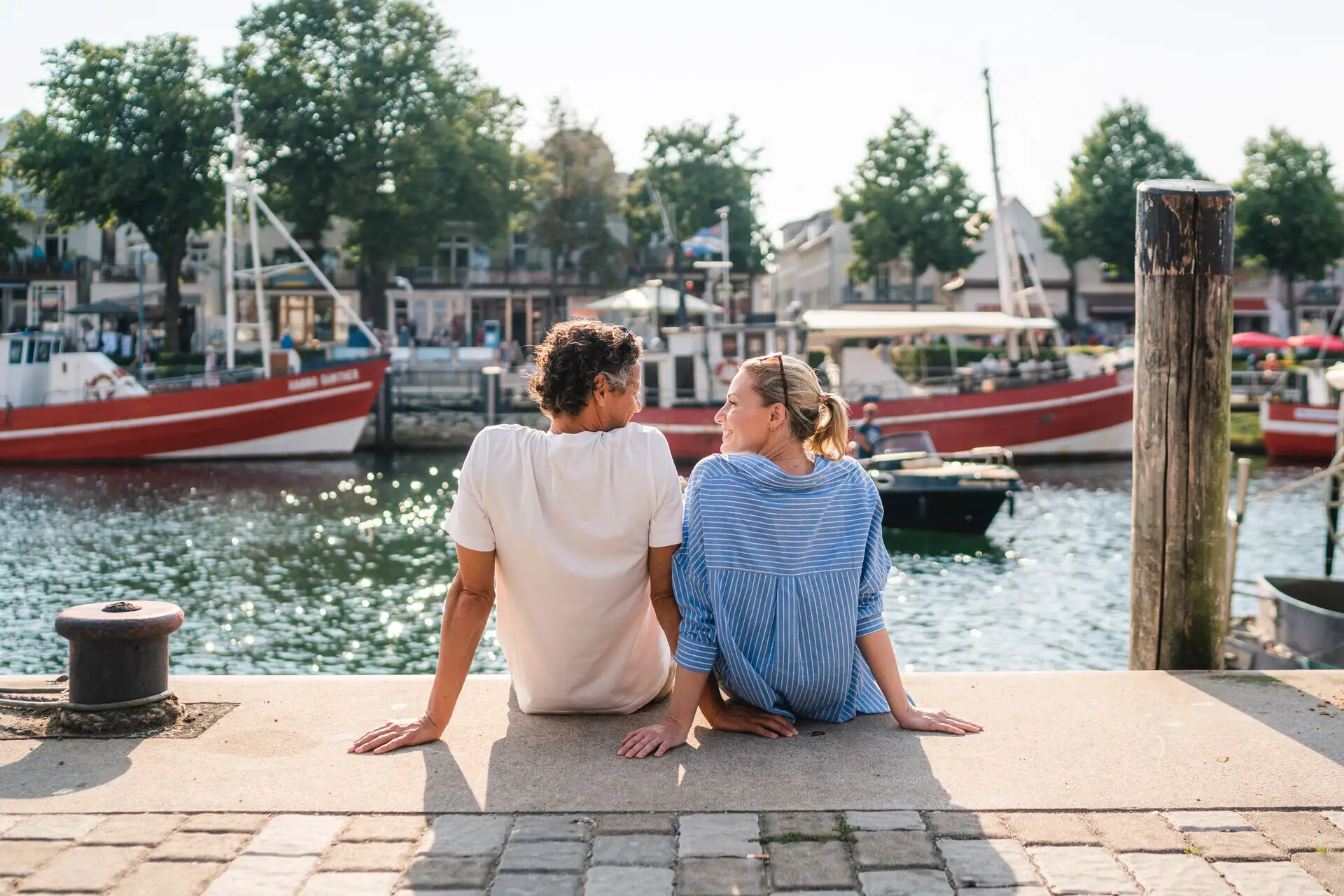 Oude stroom Een man en een vrouw zitten op een richel en kijken elkaar aan.
