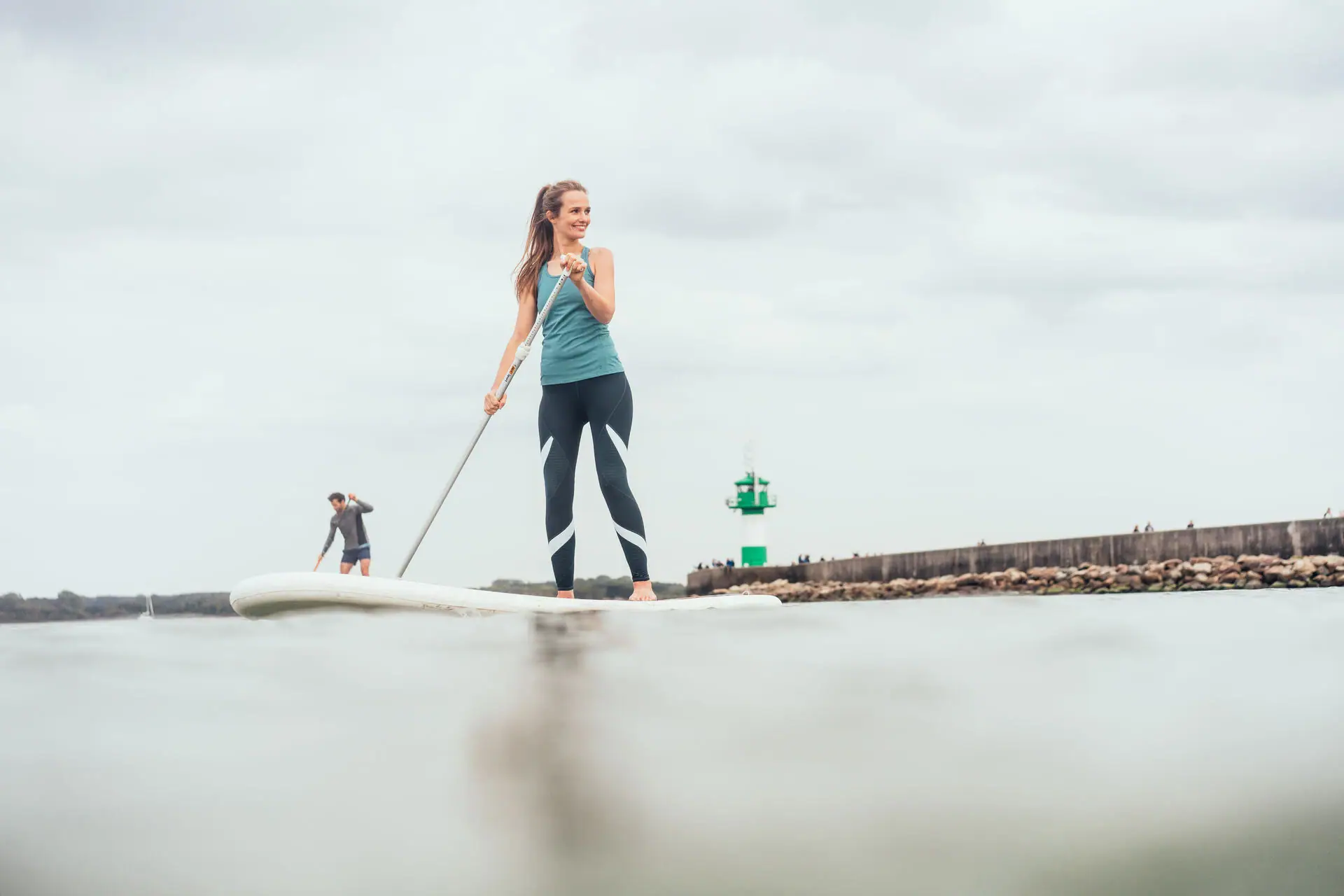 SUP op de Oostzee Een vrouw en een man op een surfplank.
