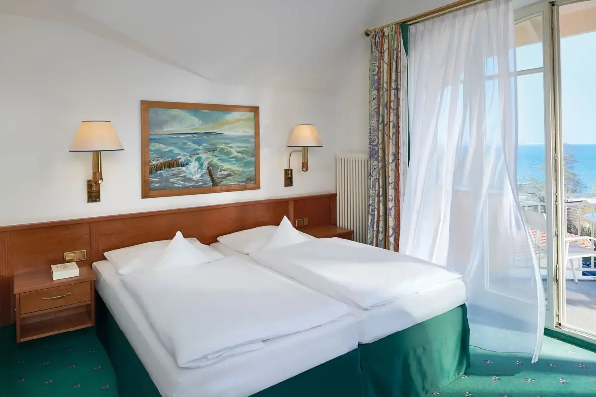 Een kamer met twee bedden en een raam.