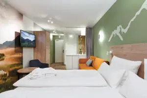 Tweepersoonskamer aja Ruhpolding Een kamer met een bed en een televisie.