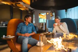 Ein Mann und eine Frau sitzen auf Stühlen und trinken Kaffee.
