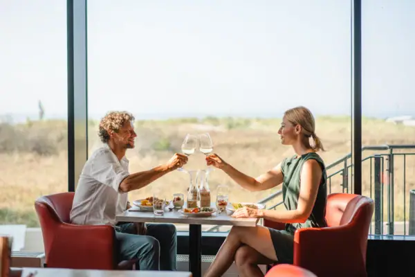 Ein Mann und eine Frau sitzen an einem Tisch mit Weingläsern.