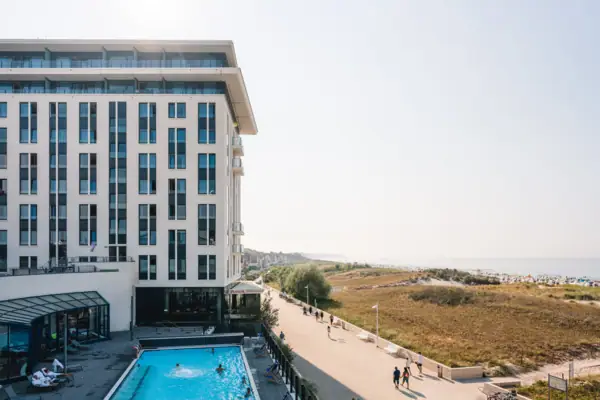 Een gebouw met een zwembad en mensen die voorbij lopen.