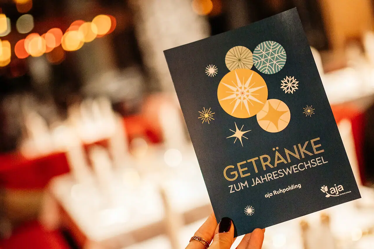 Eén hand houdt een drankmenu vast voor oudejaarsavond